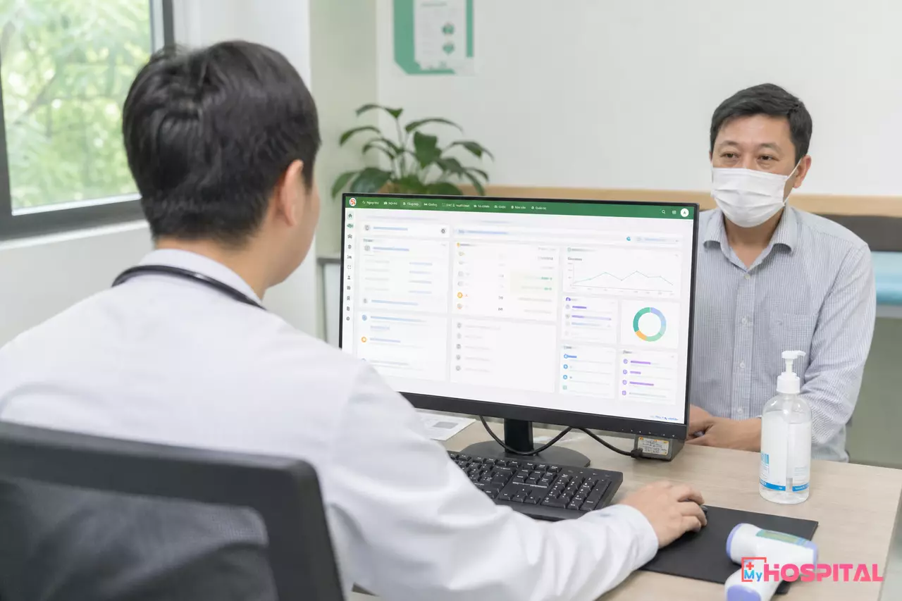 Bác sĩ kê đơn thuốc điện tử trên máy tính trong phòng khám