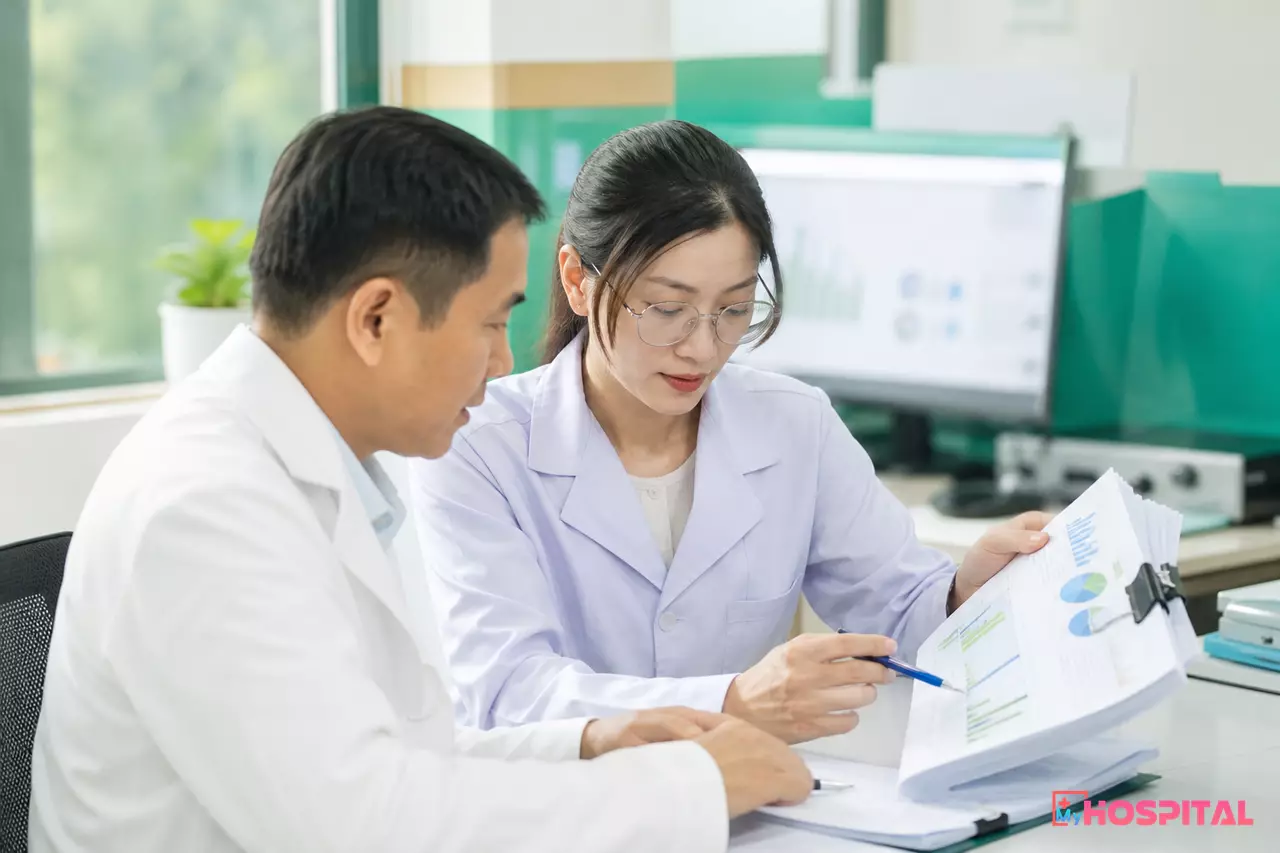 Hai cán bộ giám định nội bộ rà soát bảng kê và biểu đồ BHYT tại phòng kế hoạch tổng hợp