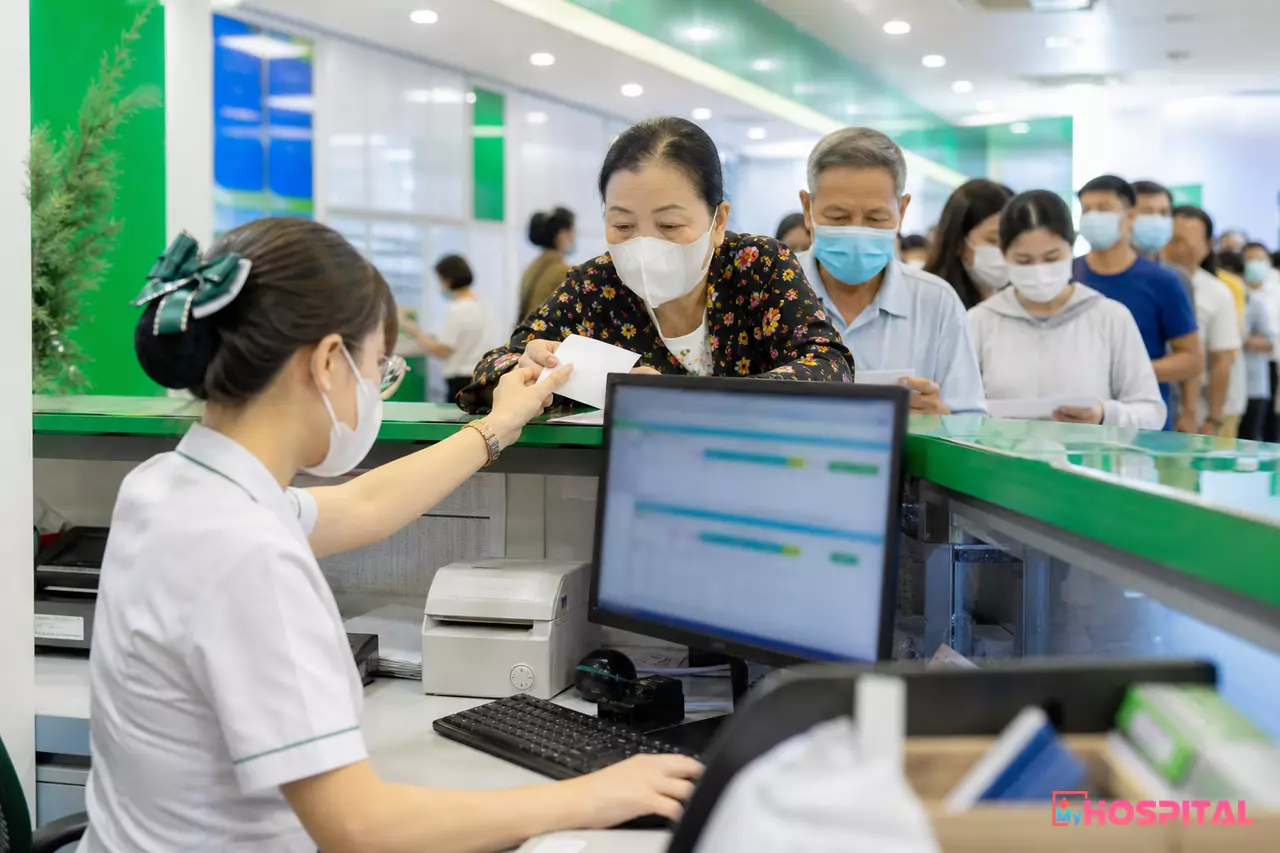 Thu ngân viện phí in biên lai cho người bệnh tại quầy thu của bệnh viện