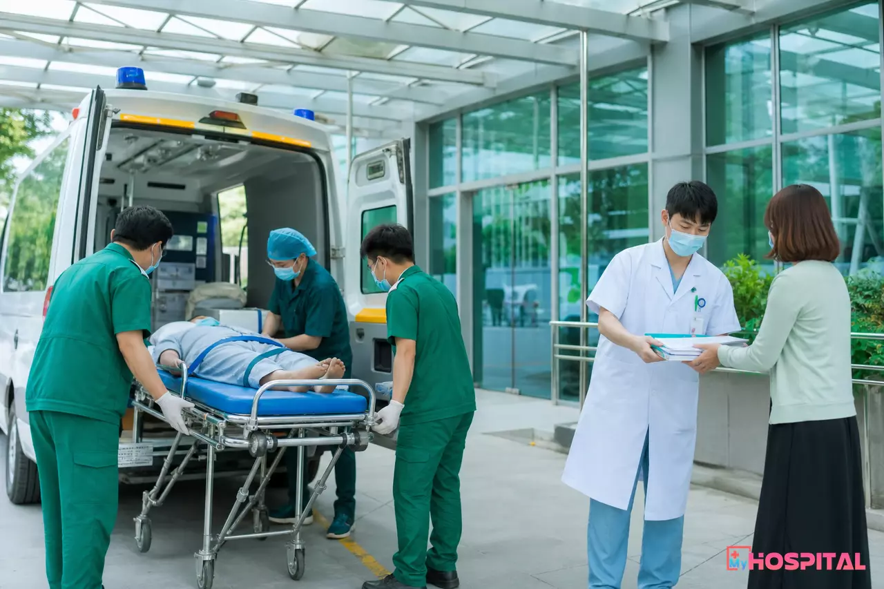 Nhân viên y tế đưa người bệnh lên xe cứu thương và bàn giao tập hồ sơ cho người đi cùng