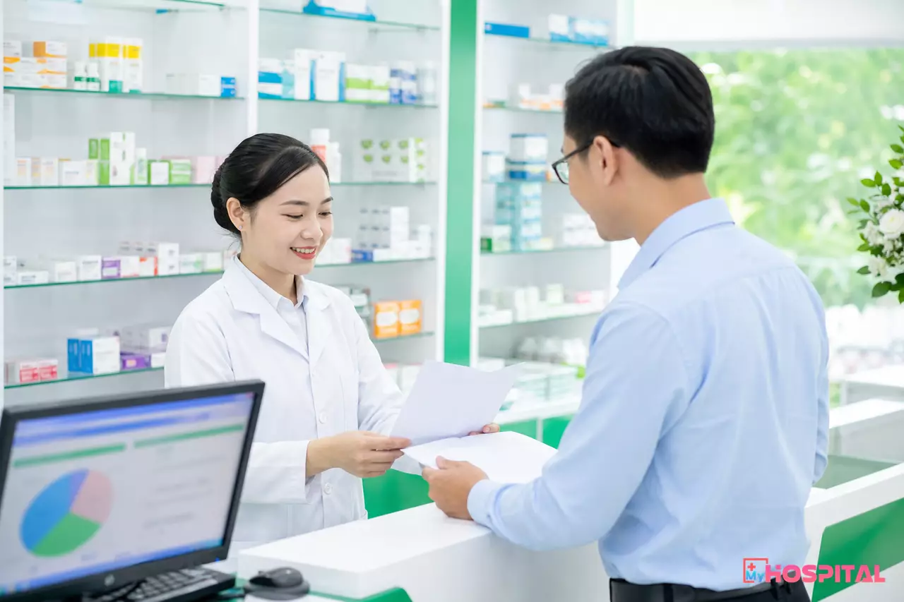 Dược sĩ tại nhà thuốc trao đổi hồ sơ giấy tờ pháp lý với đoàn kiểm tra