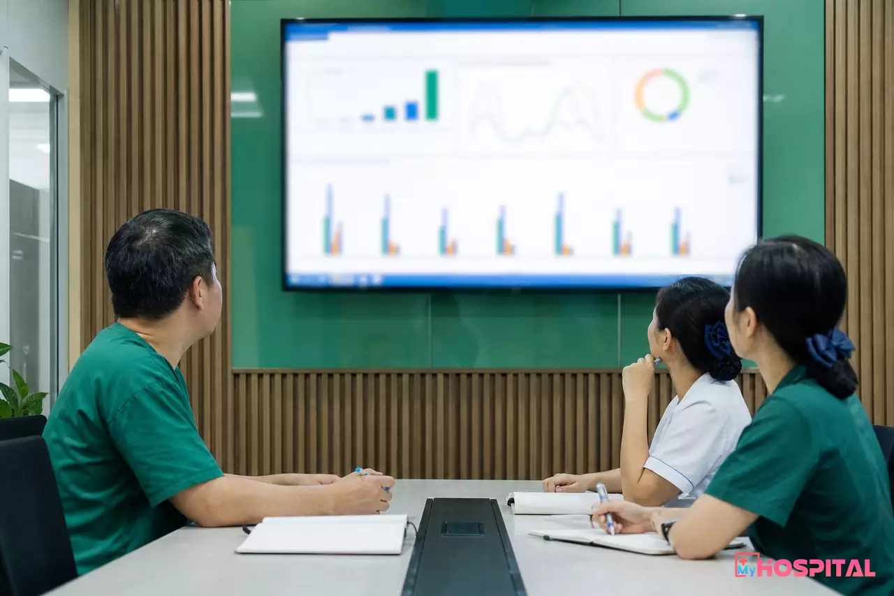 Trưởng khối phẫu thuật và điều dưỡng trưởng phòng mổ cùng xem biểu đồ công suất phòng mổ trong buổi giao ban
