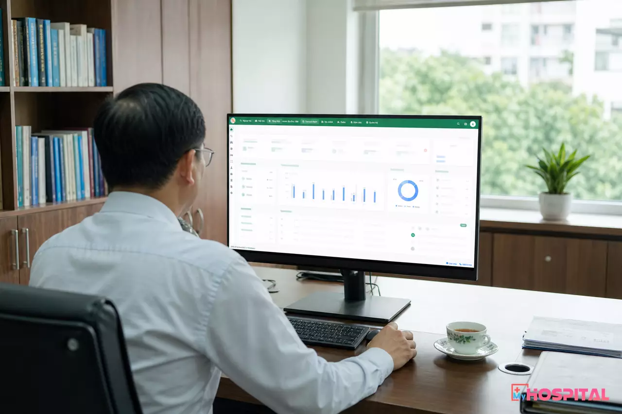 Giám đốc bệnh viện xem dashboard báo cáo quản trị trên máy tính trong phòng làm việc