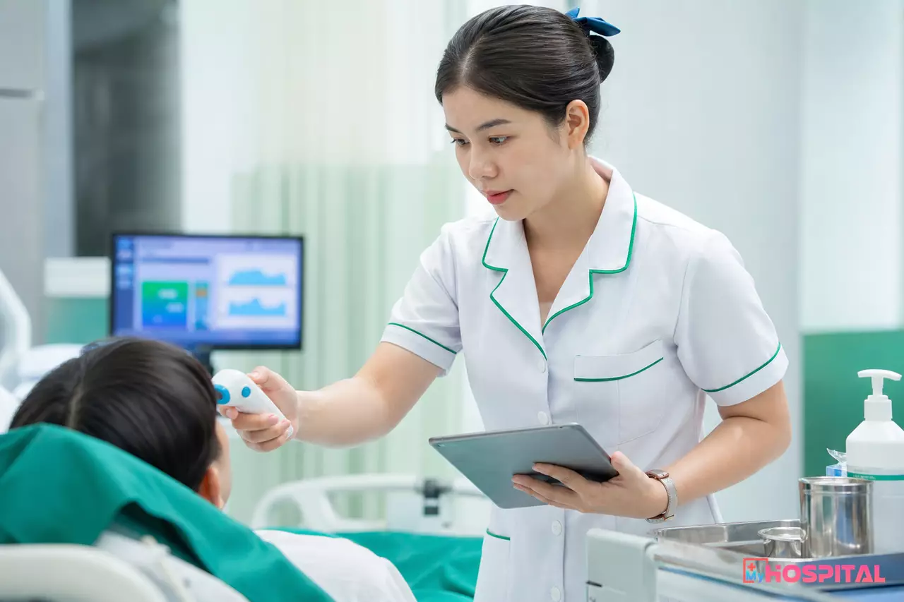Điều dưỡng đo dấu hiệu sinh tồn và ghi ngay vào máy tính bảng tại giường bệnh