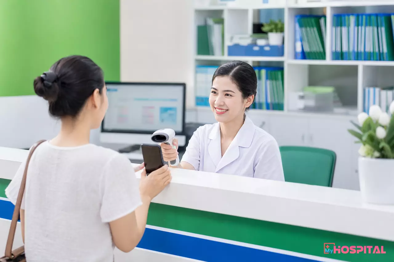 Nhân viên thu ngân phòng khám tư nhân quét mã QR thanh toán viện phí tại quầy tiếp đón