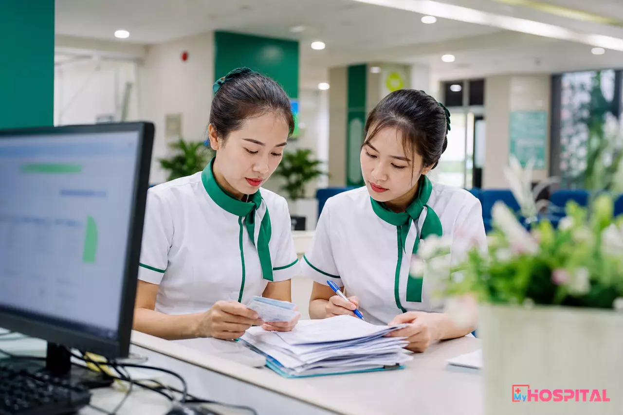 Nhân viên bộ phận tiếp đón bệnh viện đối chiếu hồ sơ người bệnh bị tách do đổi số thẻ BHYT