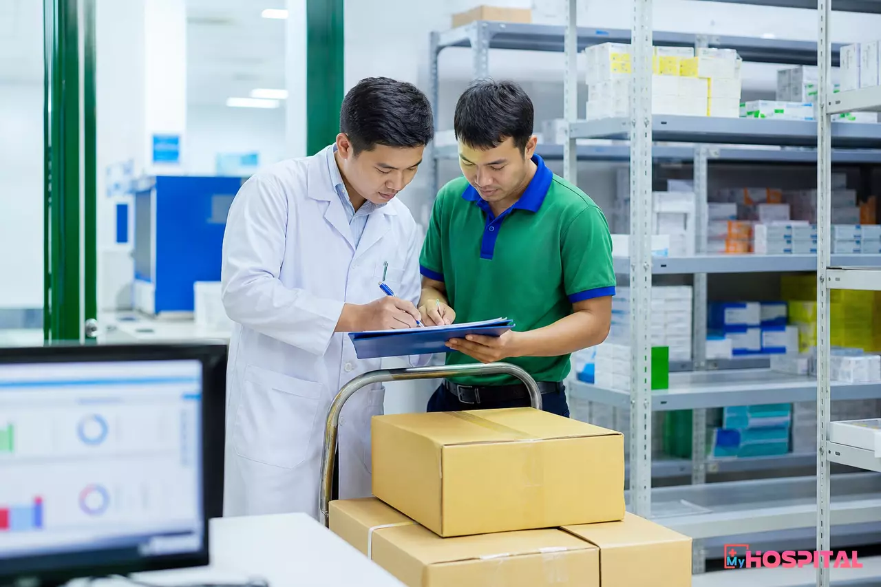 Nhân viên kho dược bệnh viện đối chiếu phiếu nhập kho thuốc với nhân viên giao hàng của nhà phân phối