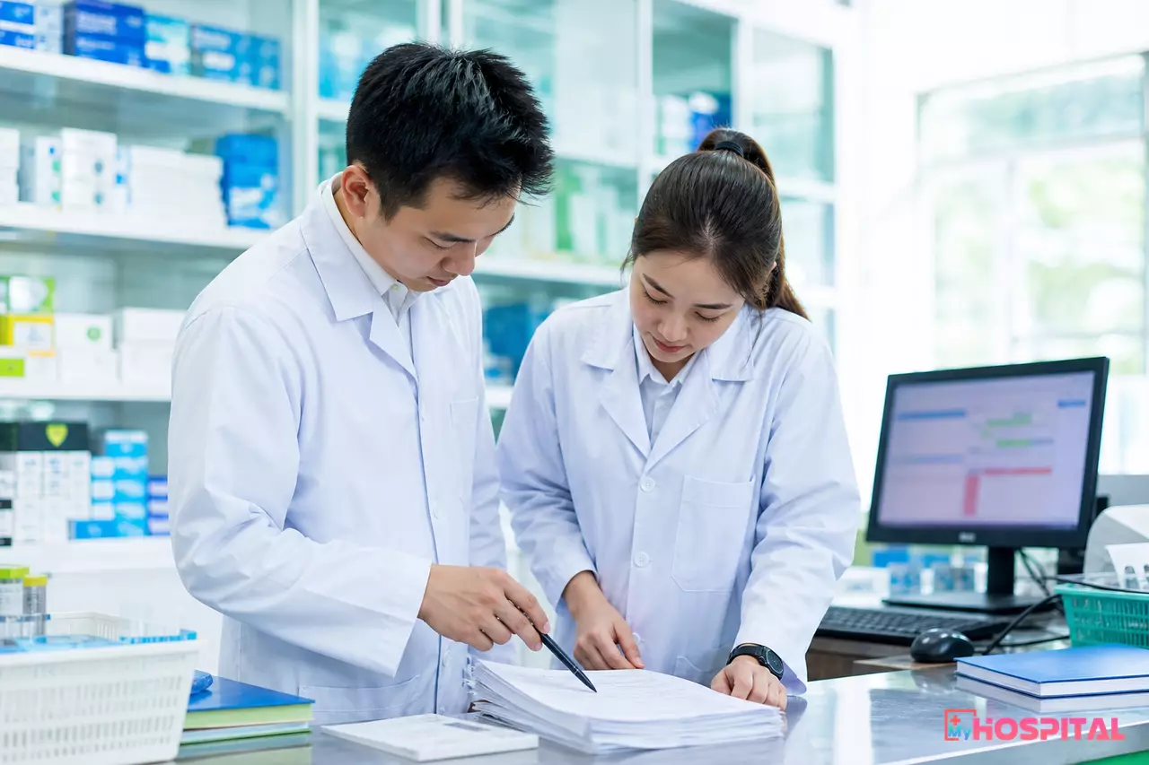Nhân viên khoa Dược đối chiếu phiếu xuất kho giấy với sổ sách trước khi tổng hợp báo cáo