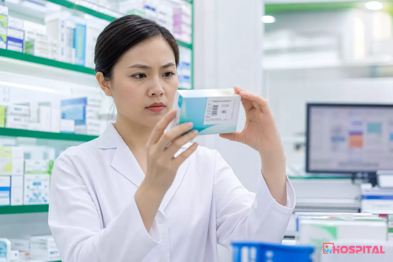 Dược sĩ tại quầy thuốc bệnh viện kiểm tra tem nhãn trên hộp thuốc nghi ngờ
