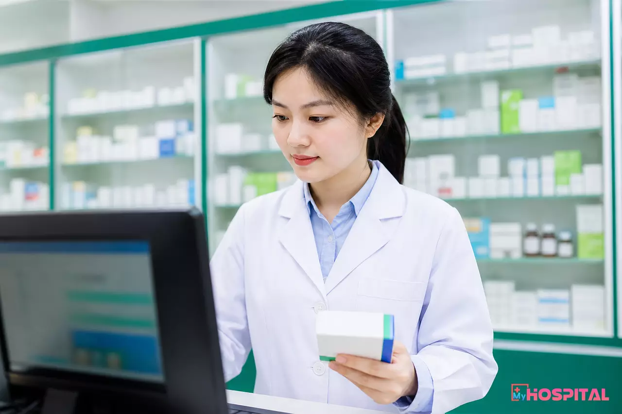 Dược sĩ tại quầy thuốc bệnh viện tra cứu số lô thuốc trên máy tính trước khi cấp phát