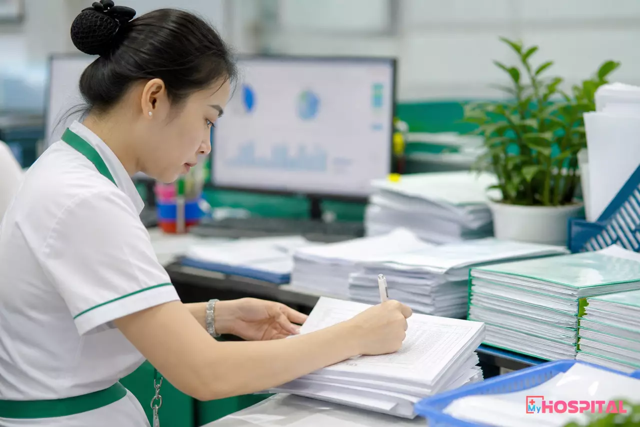 Kế toán viện phí đối chiếu hồ sơ xuất toán tại bàn làm việc