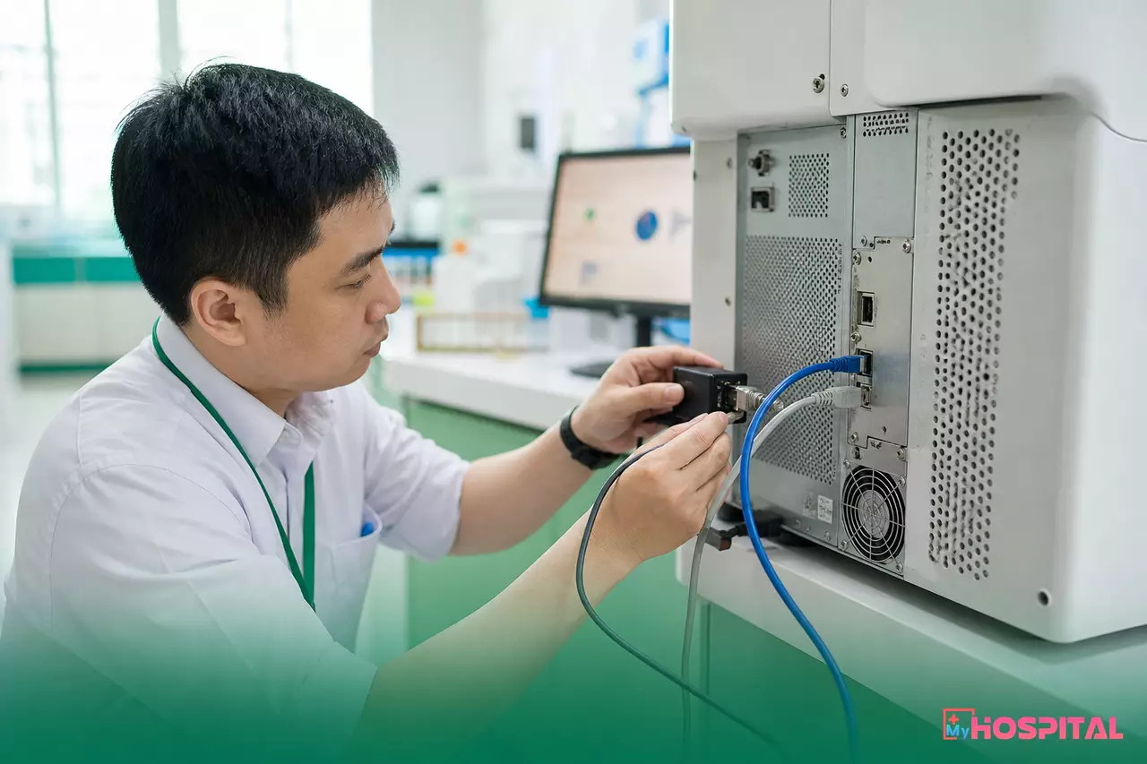 Kỹ sư công nghệ thông tin gắn bộ chuyển đổi cổng nối tiếp vào mặt sau máy xét nghiệm huyết học