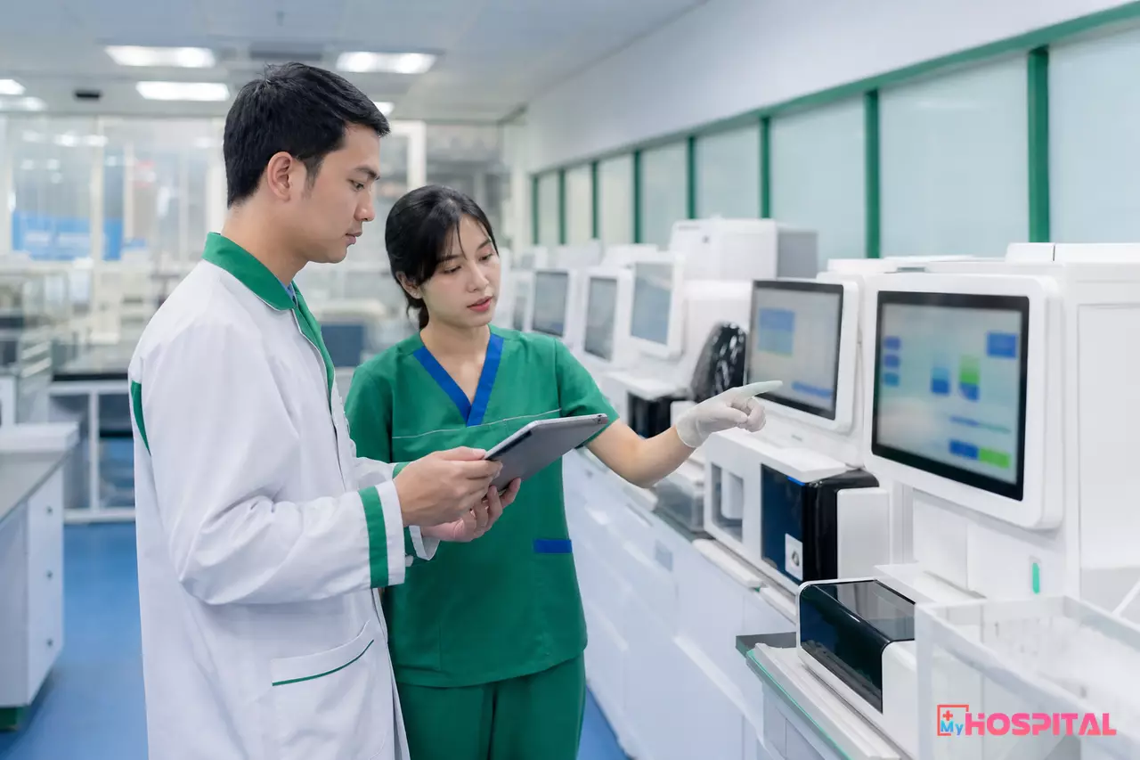 Kỹ sư CNTT kiểm kê dãy máy phân tích trong phòng xét nghiệm trước khi triển khai LIS