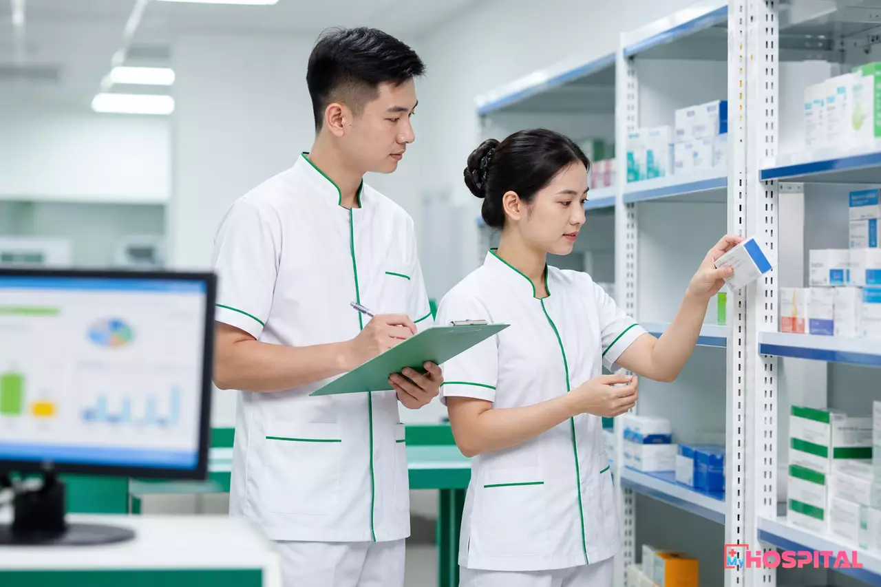 Hai nhân viên kho dược kiểm đếm mẫu thuốc theo nhóm giá trị cao trên kệ