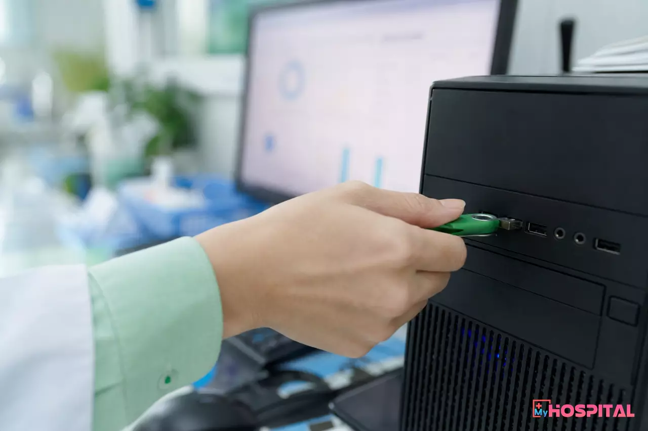 Nhân viên bệnh viện cắm thiết bị chữ ký số vào máy tính trước khi ký số file XML BHYT