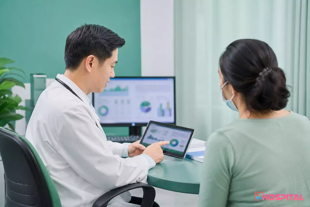 Bác sĩ phòng khám xem kết quả xét nghiệm trên máy tính bảng cùng người bệnh