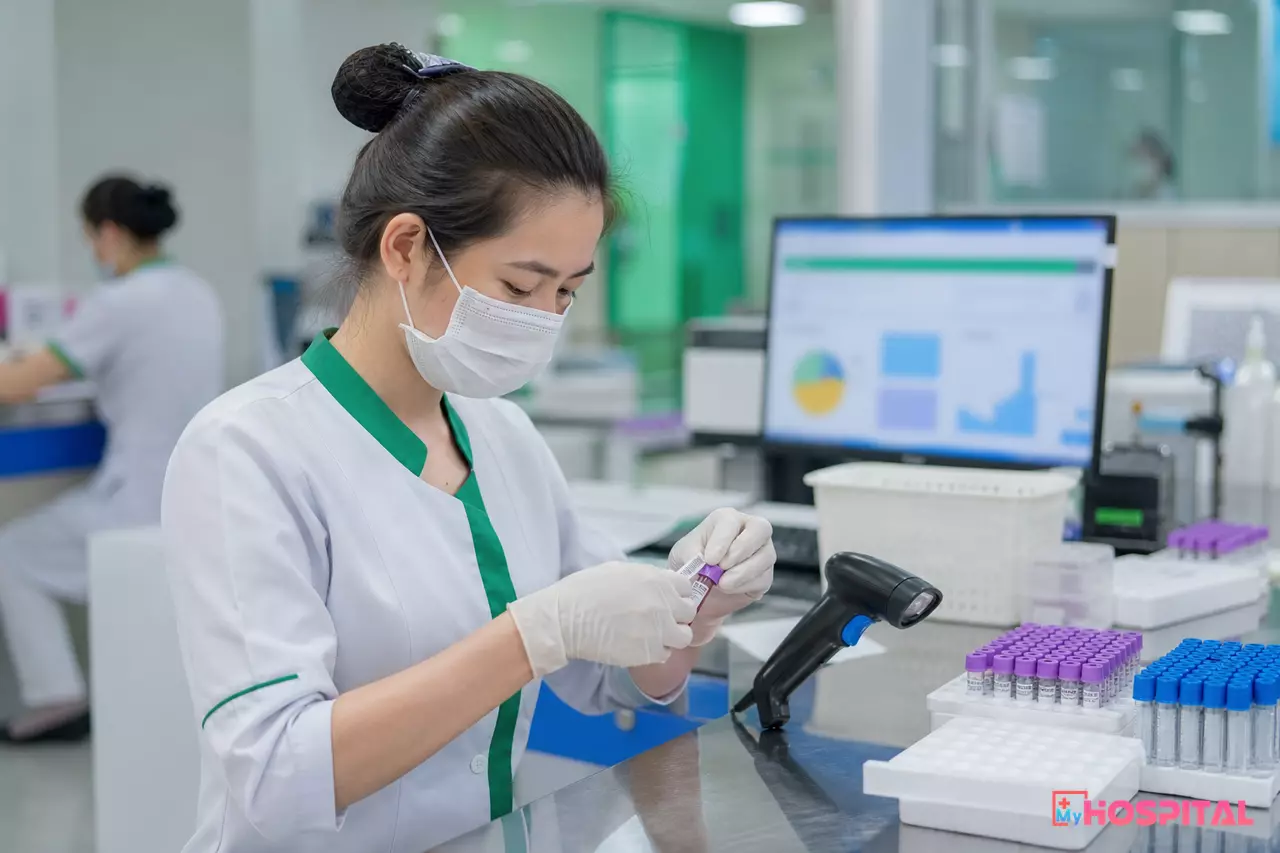 Kỹ thuật viên dán nhãn mã vạch lên ống máu tại quầy nhận mẫu của phòng xét nghiệm