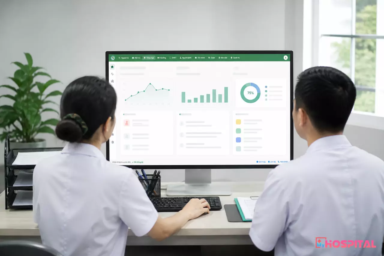 Hai cán bộ cùng quan sát báo cáo kết quả giám định BHYT trên màn hình HIS