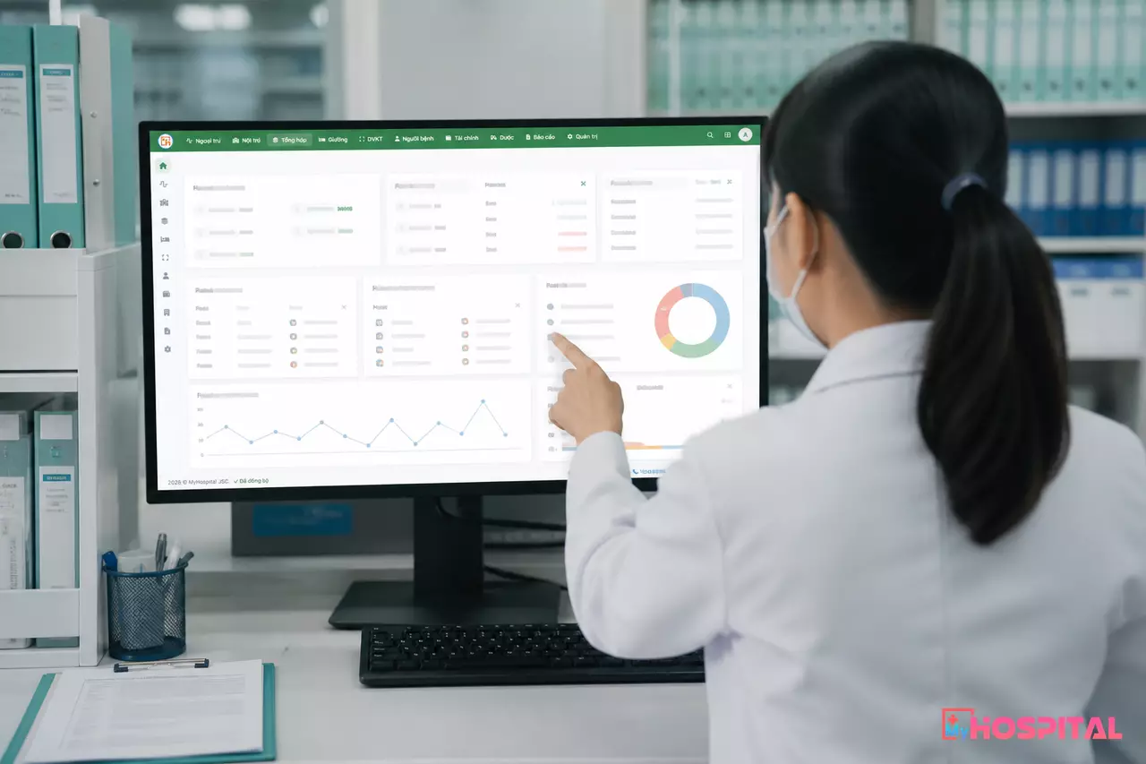 Màn hình máy tính hiển thị cấu trúc danh mục thuốc phân theo hoạt chất và mã thuốc cụ thể trên phần mềm bệnh viện, dược sĩ thao tác từ phía sau