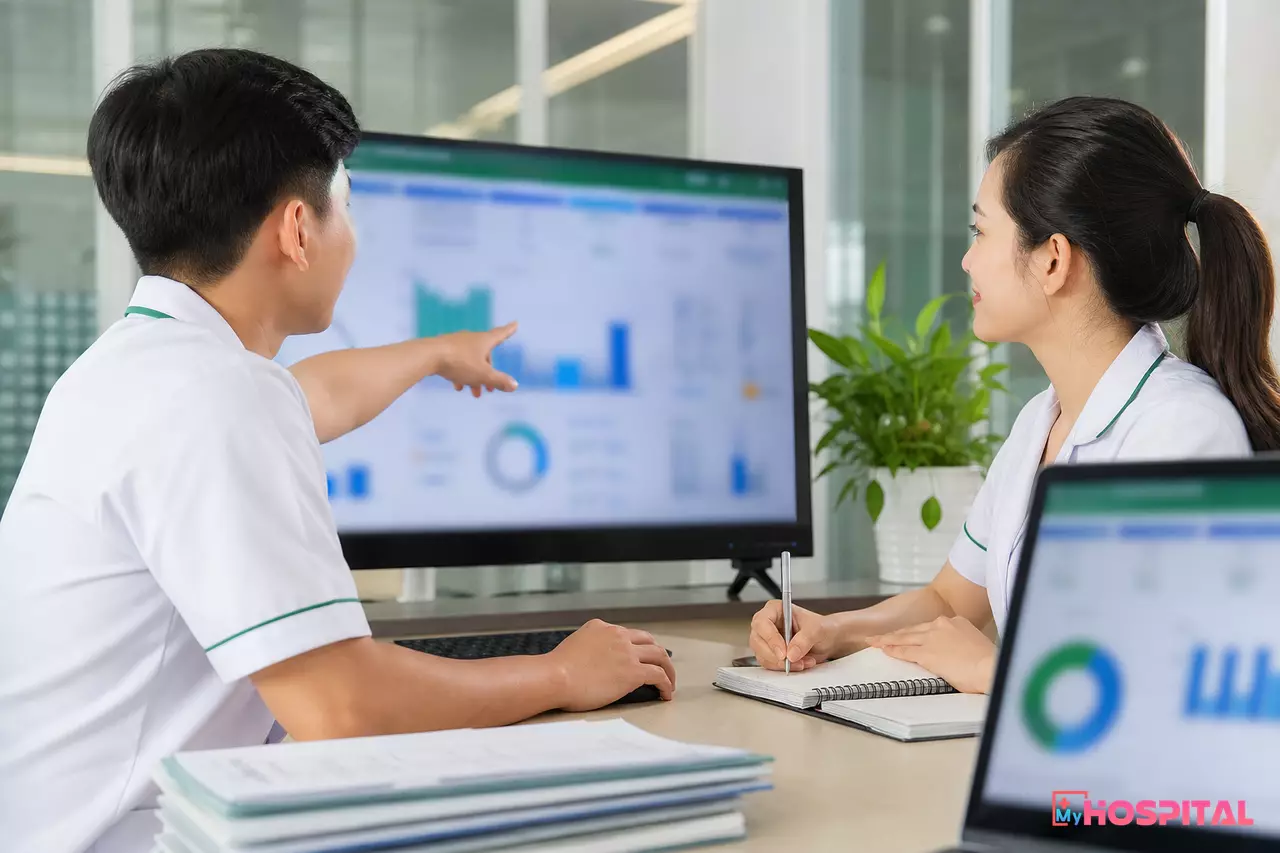 Nhân viên viện phí và giám định BHYT thảo luận trước màn hình máy tính về dữ liệu giám định