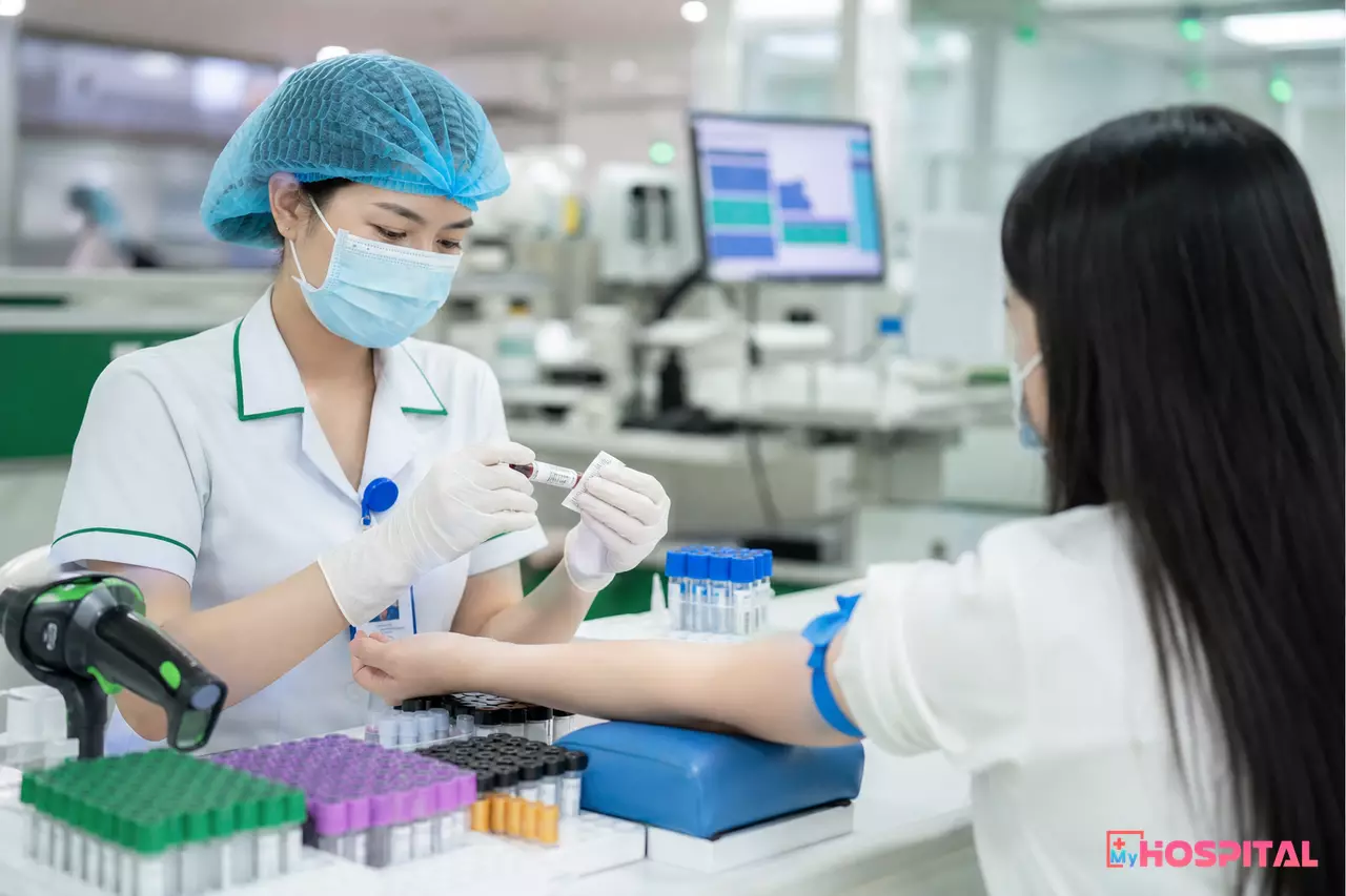 Điều dưỡng dán nhãn mã vạch lên ống máu tại phòng lấy mẫu xét nghiệm