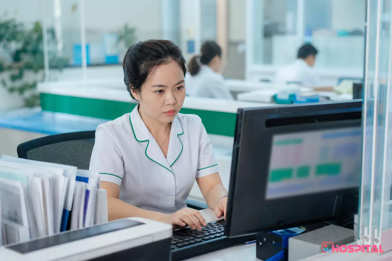 Kế toán viện phí bệnh viện kiểm tra lại dữ liệu phơi thu ngân trên máy tính