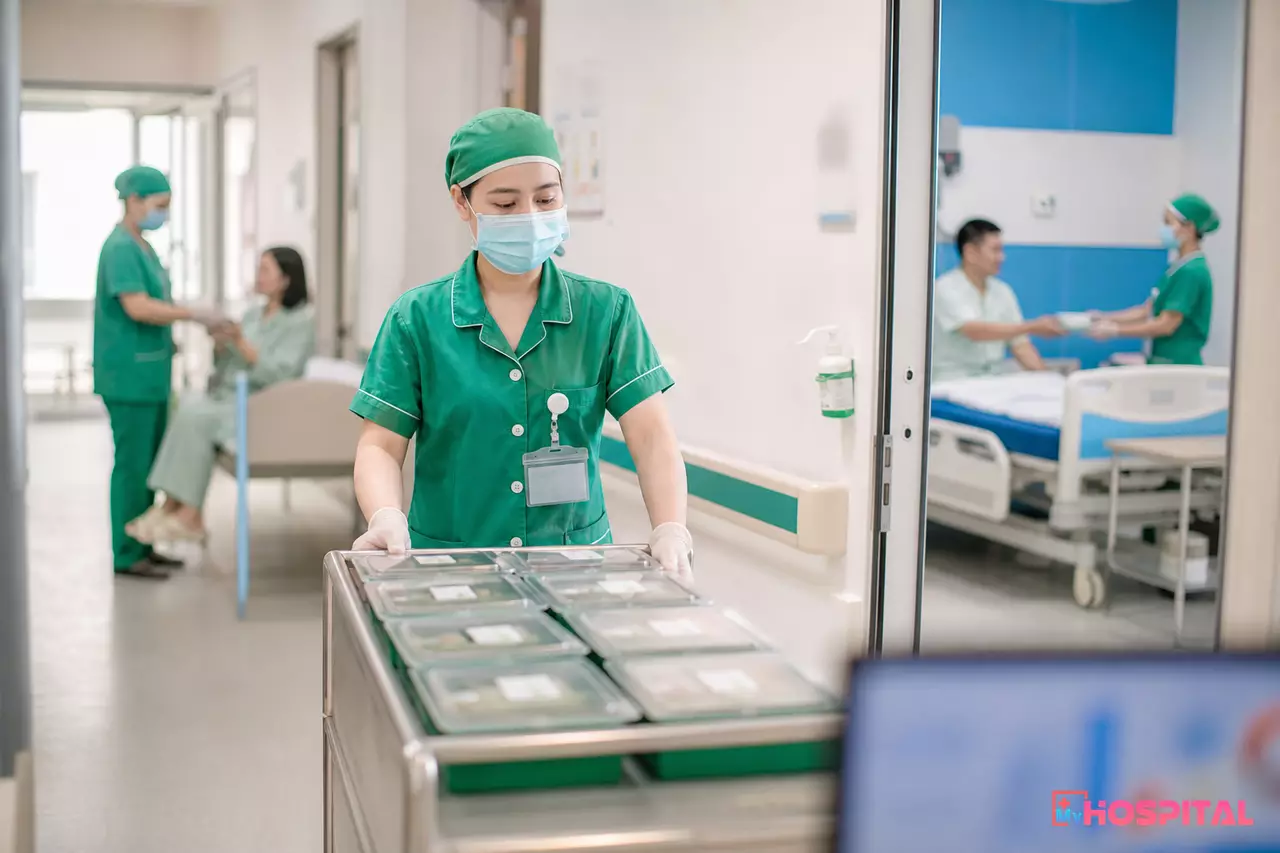 Nhân viên bộ phận dinh dưỡng đẩy xe chia suất ăn dọc hành lang khoa nội trú