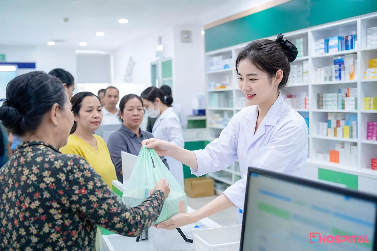Dược sĩ tại quầy thuốc bệnh viện cấp phát thuốc cho người bệnh