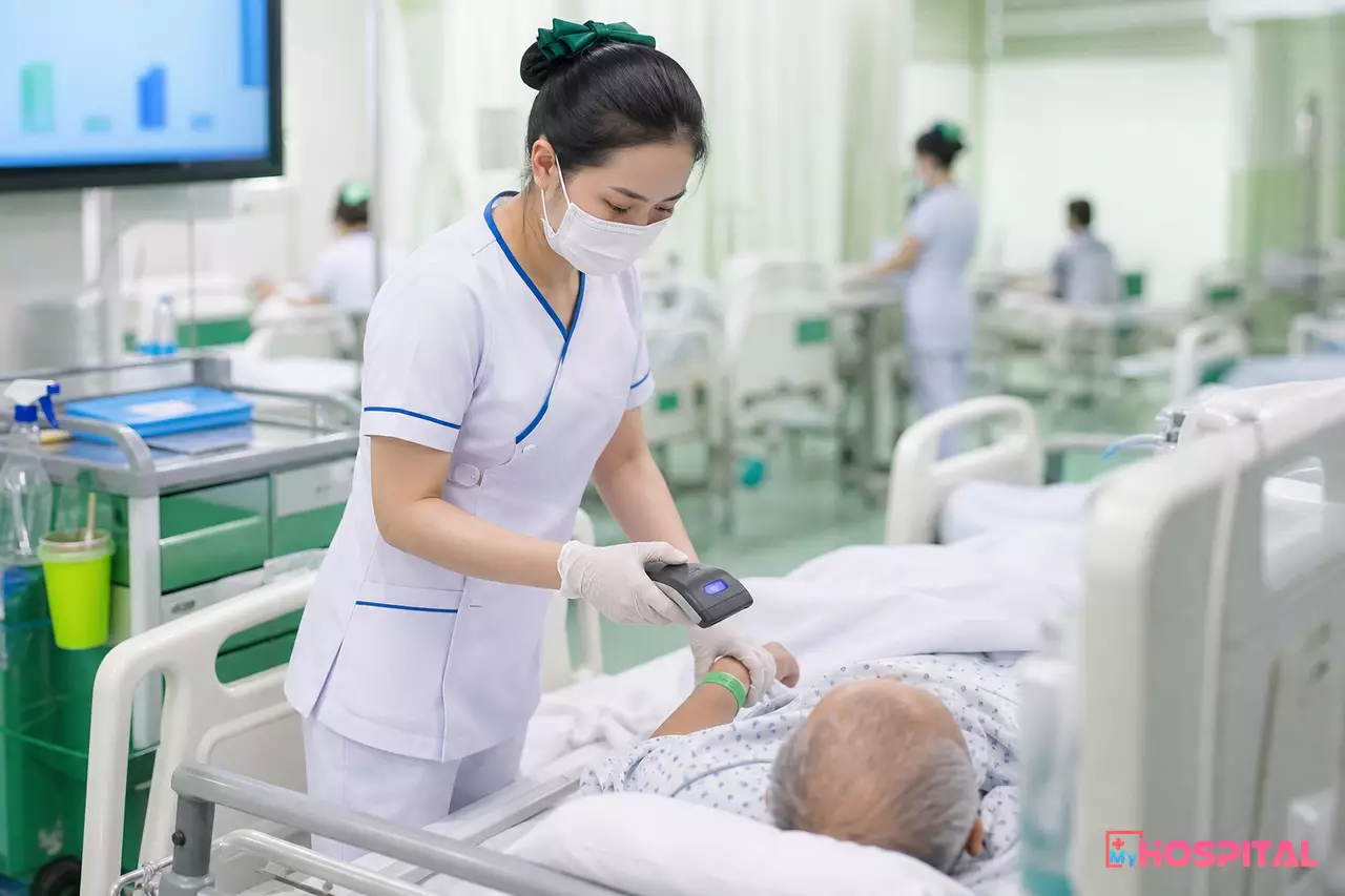 Điều dưỡng quét vòng đeo tay người bệnh tại giường trước khi dùng thuốc
