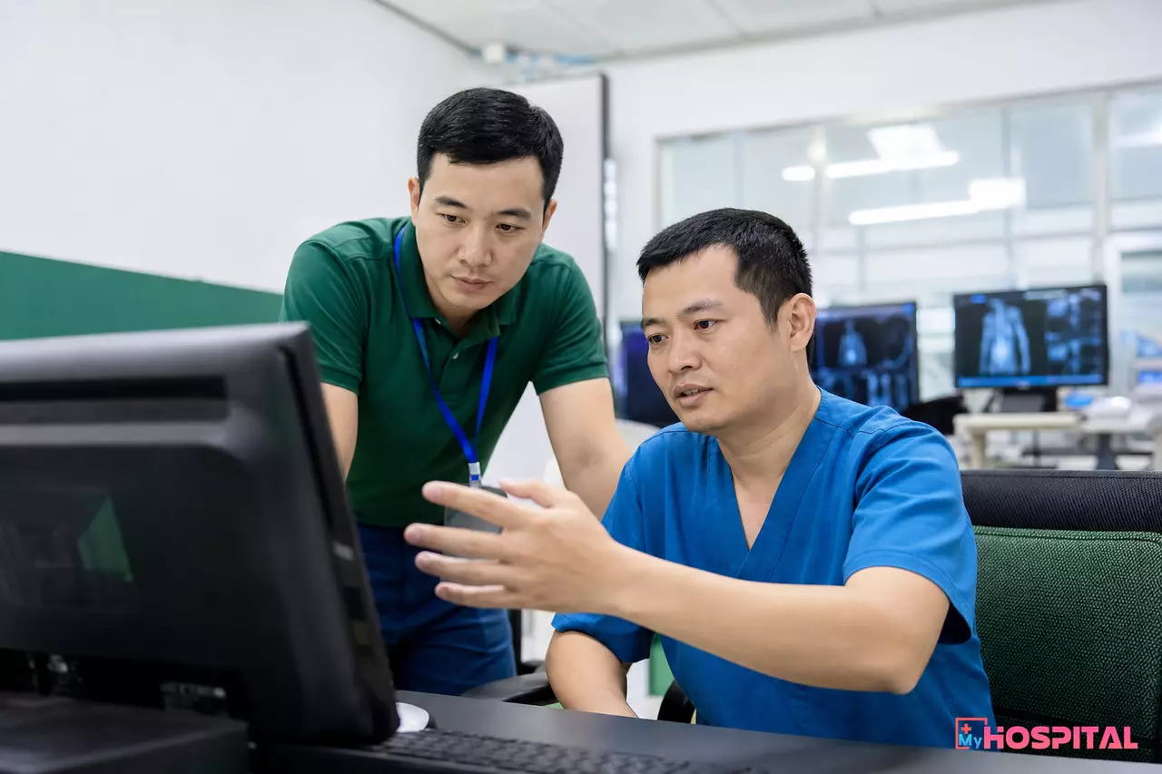 Cán bộ IT và kỹ thuật viên chẩn đoán hình ảnh cùng đối soát lỗi đồng bộ giữa hai hệ thống