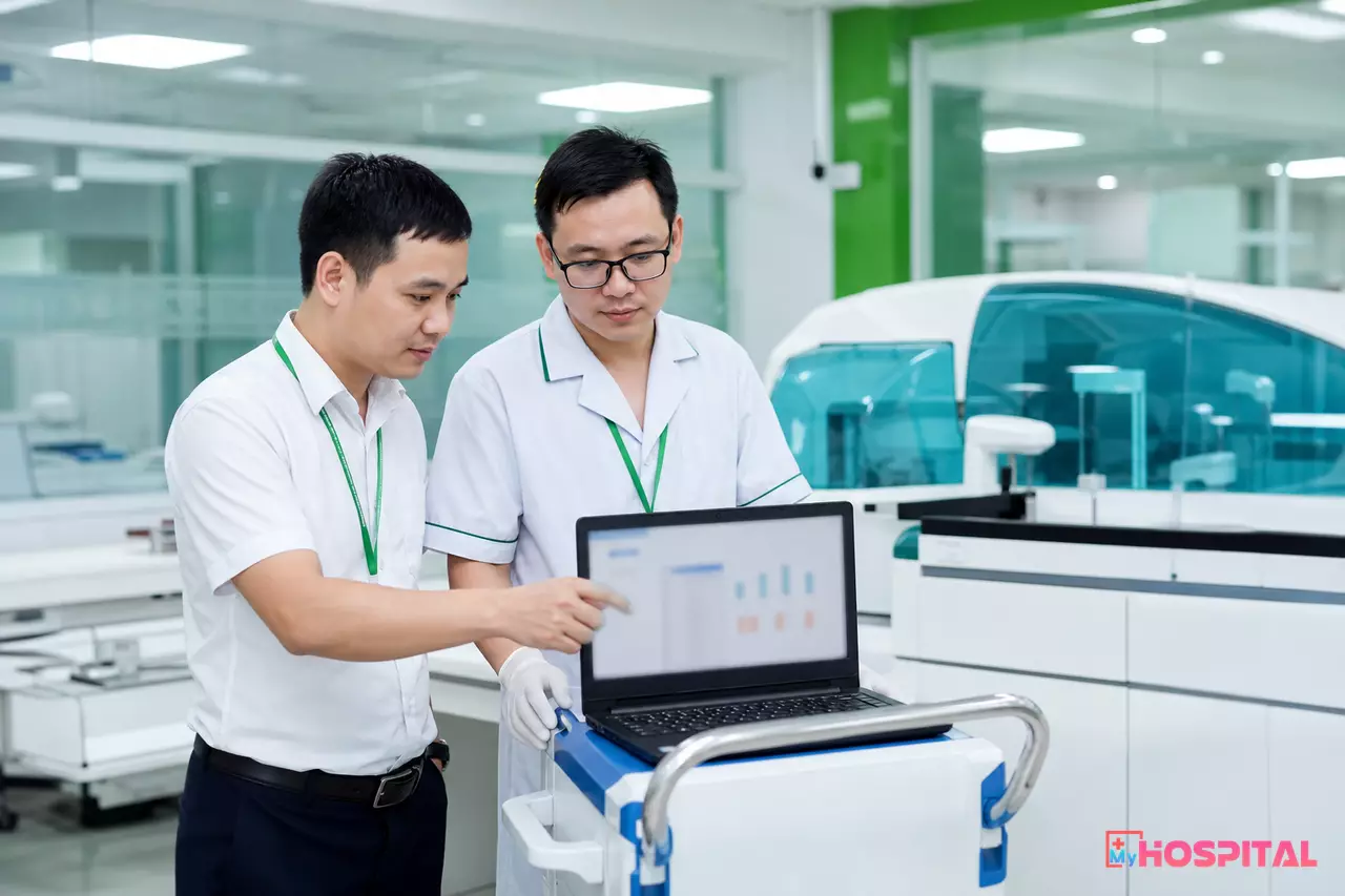 Kỹ sư công nghệ thông tin và kỹ thuật viên xét nghiệm cùng kiểm tra kết nối của máy phân tích tự động