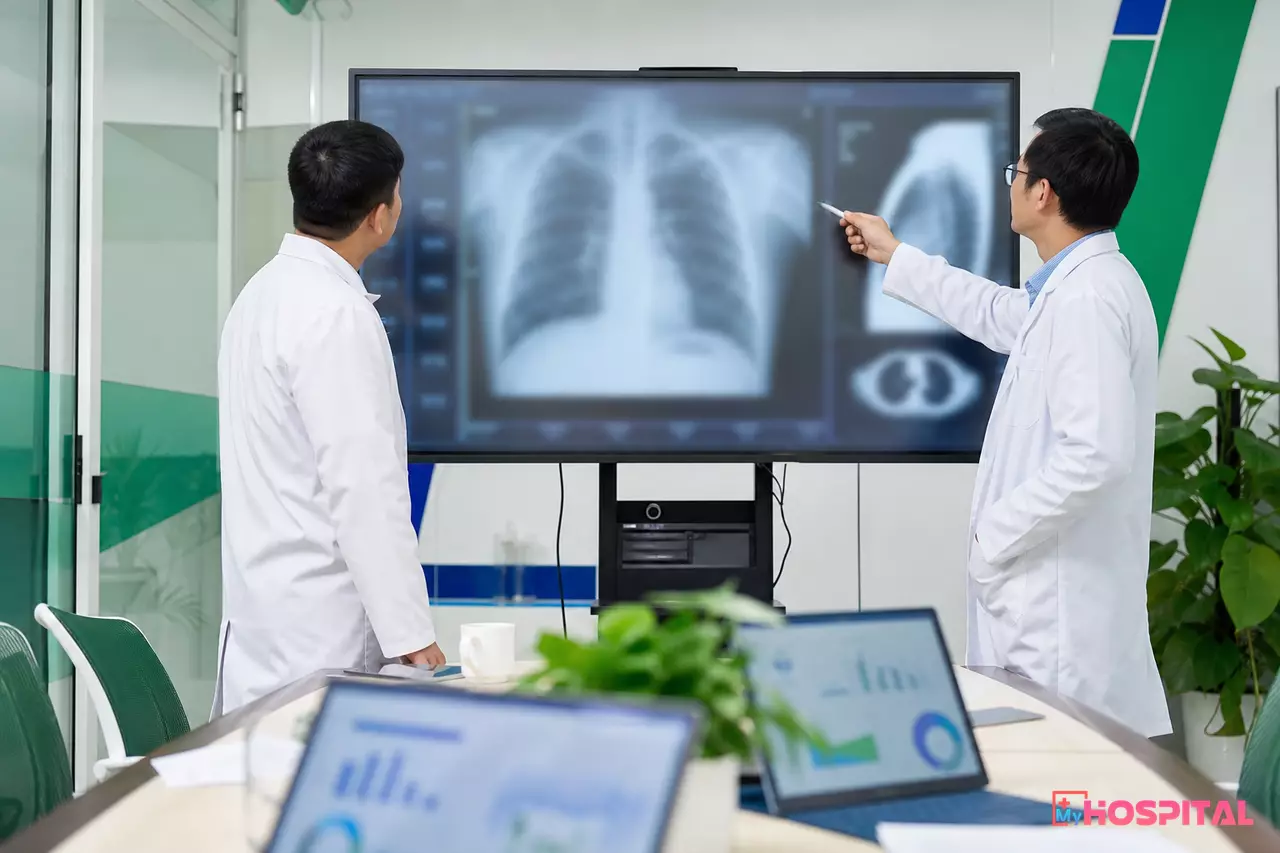 Hai bác sĩ trao đổi trước màn hình phim X-quang trong buổi hội chẩn