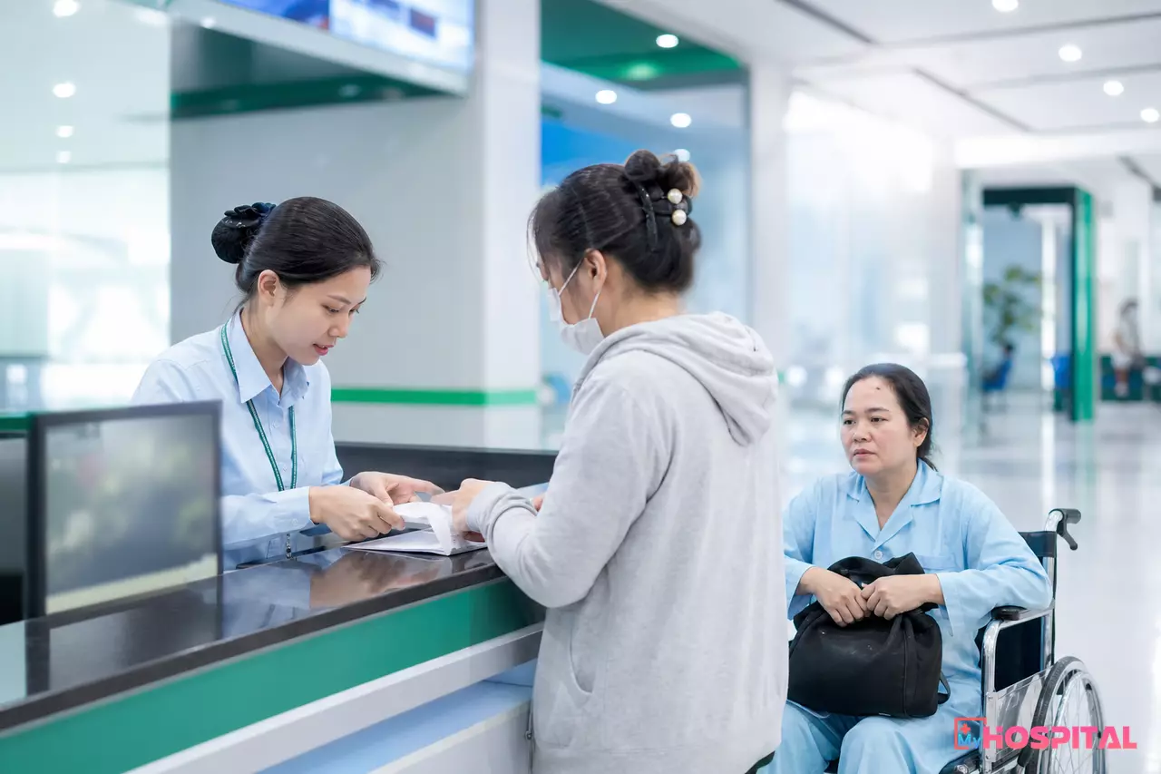 Nhân viên thu ngân viện phí xử lý nhanh thủ tục thanh toán ra viện cho người nhà người bệnh