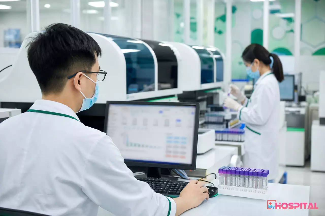 Bác sĩ xét nghiệm duyệt kết quả trước dãy máy phân tích