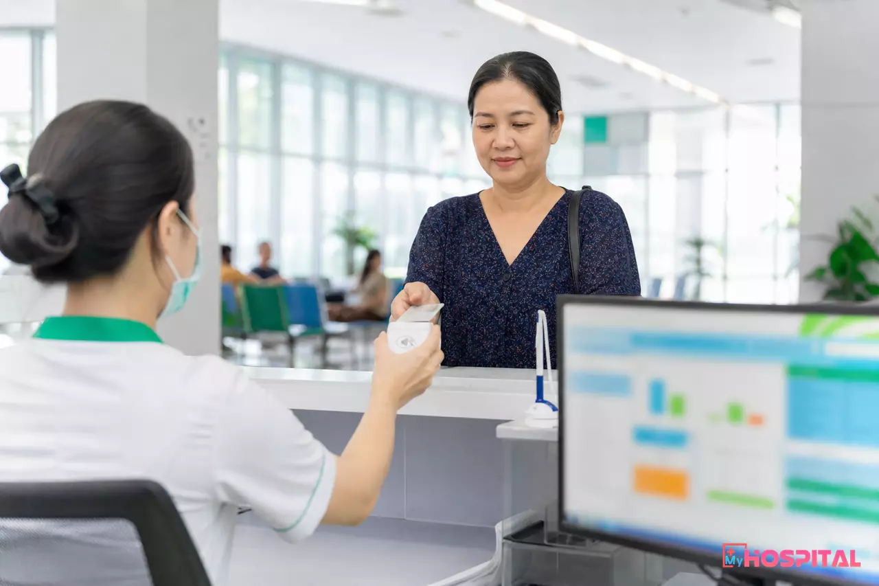 Nhân viên bộ phận tiếp đón nhập định danh người bệnh tại quầy làm thủ tục khám chữa bệnh