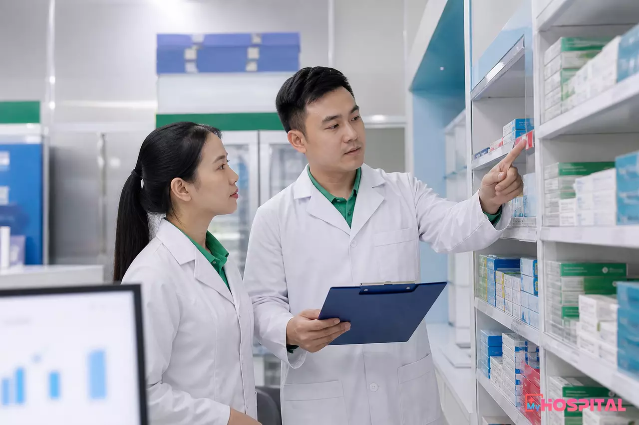 Trưởng khoa dược và dược sĩ trao đổi tại kho thuốc về lô thuốc cần xử lý gấp
