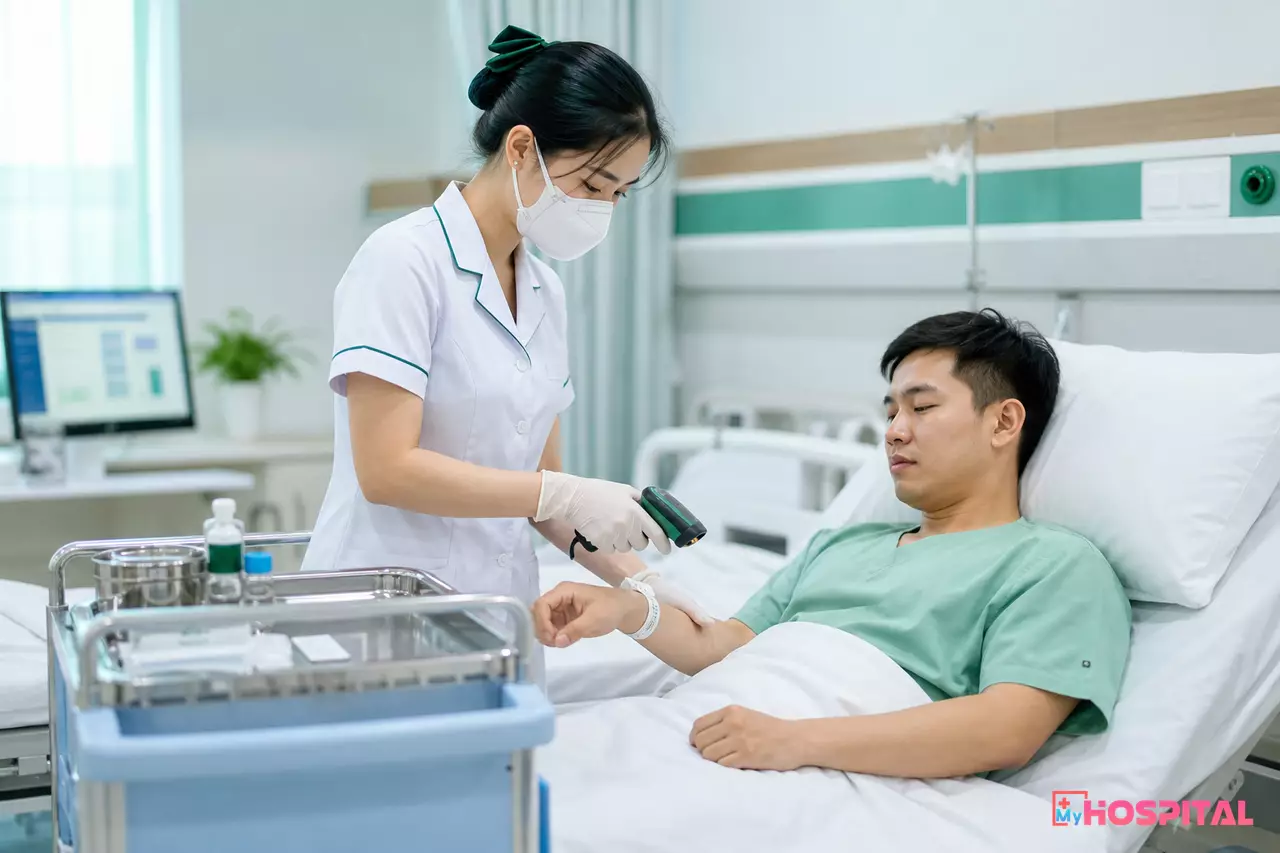 Điều dưỡng quét mã vòng đeo tay của người bệnh bằng máy quét cầm tay trước khi phát thuốc tại giường